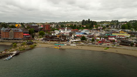 picturesque town of puerto varas on shore of lake llanquihue, beach, pier, and german-influenced architecture, patagonia, chile. aerial backward