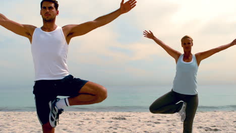 amigos en posiciones de yoga en la playa