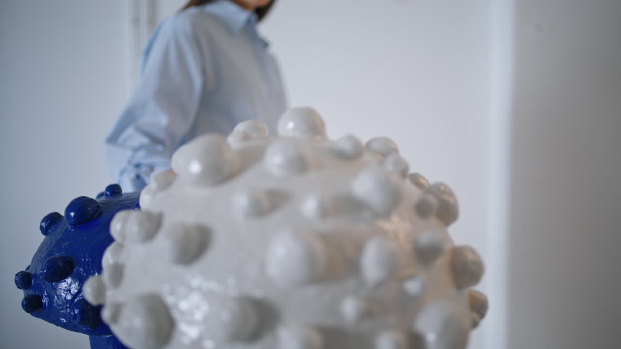 женщина, касающаяся рукой керамической скульптуры крупного плана. клиент, посещающий художественное украшение