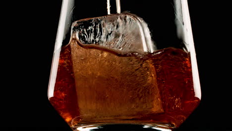 vertiendo whisky con hielo