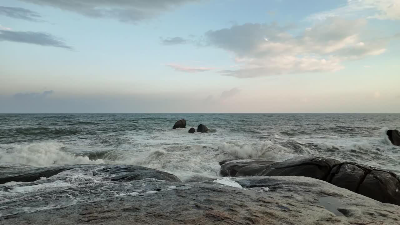 Movimento rallentato di onde oceaniche che si infrangono dolcemente contro le rocce.