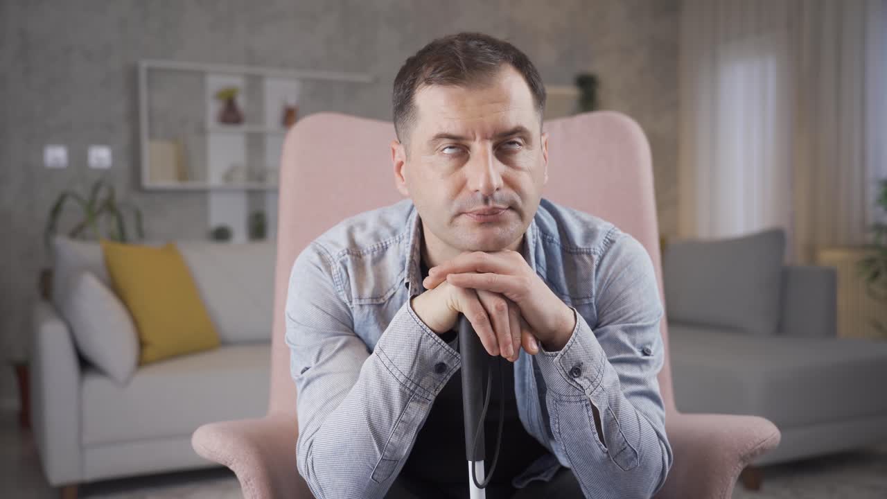 un hombre ciego pensativo sentado solo en casa.