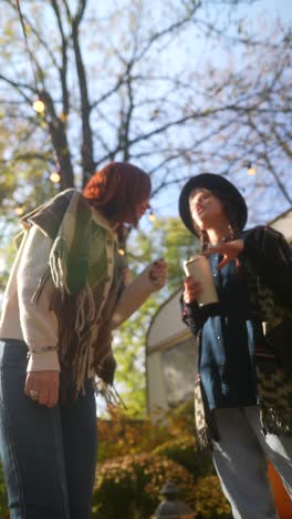 two women talking outdoors in autumn