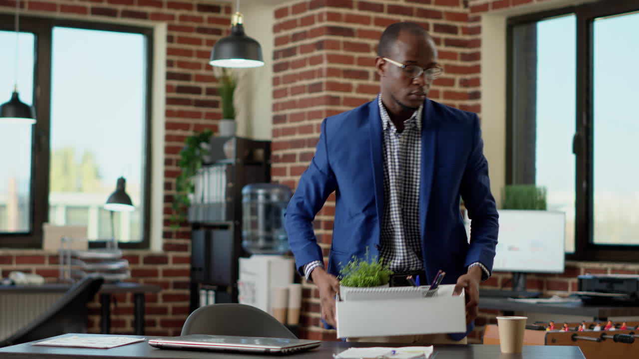 Depressed worried man gathering things to leave company job