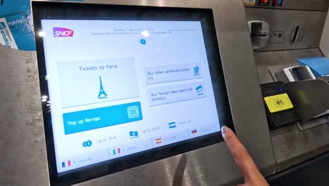 person using touchscreen to buy train tickets