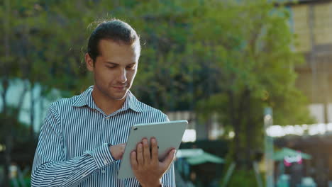 man using a tablet outdoors