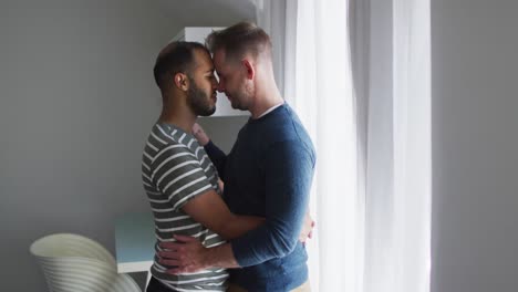 Multi-ethnic-gay-male-couple-embracing-and-smiling
