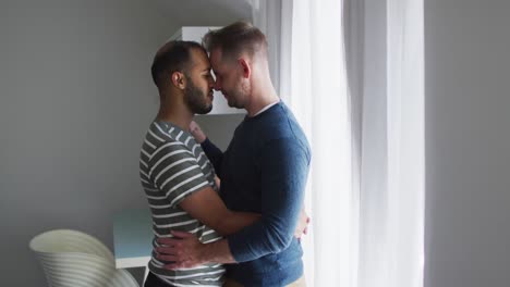 multi ethnic gay male couple embracing and smiling
