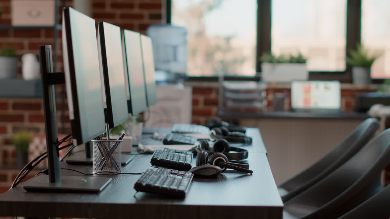 Empty call center workstation with headsets and computers
