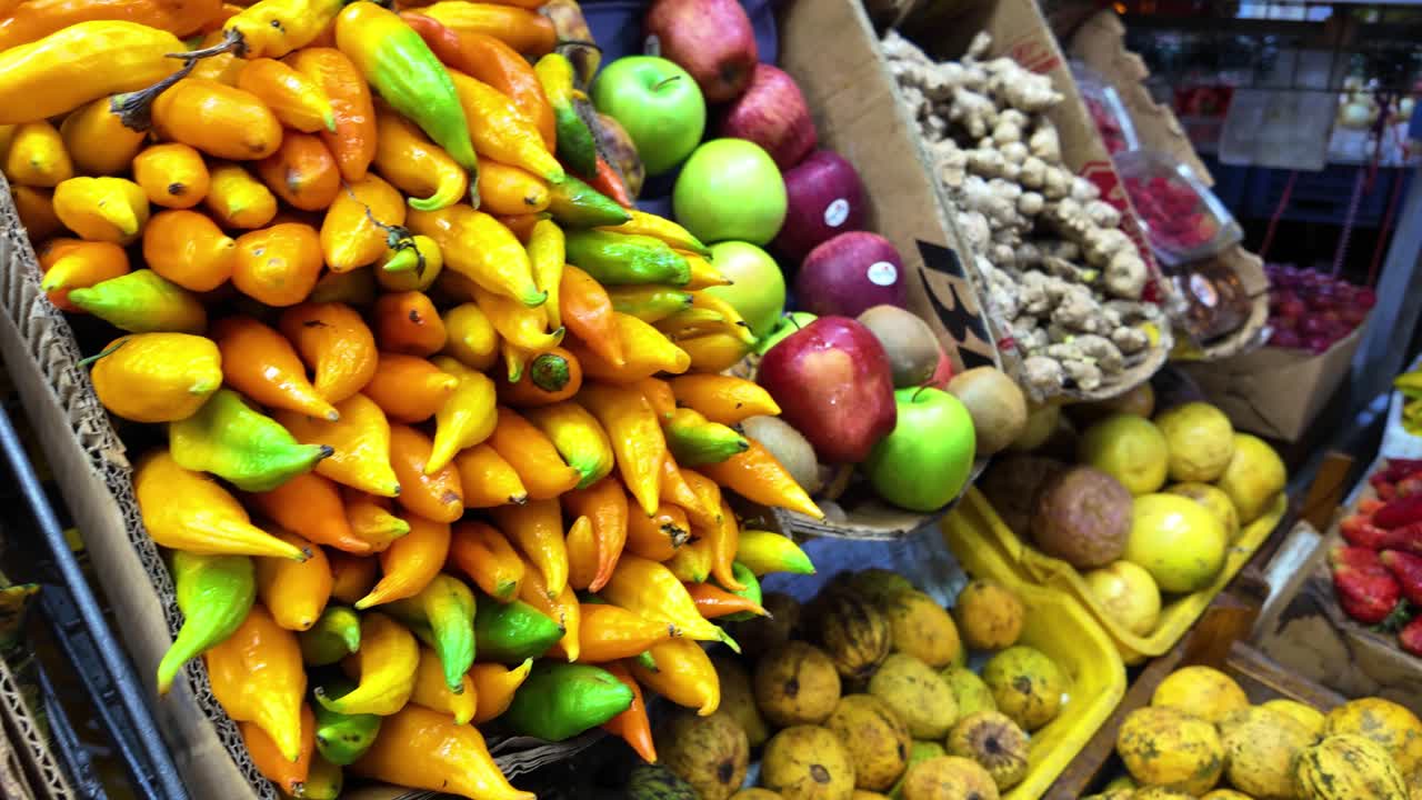 Experience a vibrant market showcasing a variety of fresh fruits and vegetables. This close-up tracking shot captures the rich colors and textures, immersing viewers in the lively atmosphere