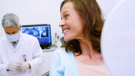 patient checking her teeth in mirror