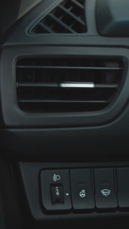 hand of woman with red nails adjusting air conditioning to stabilize temperature in car. female driver sits in vehicle turning on cooling system closeup