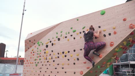 Frau-Klettert-An-Der-Outdoor-Kletterwand