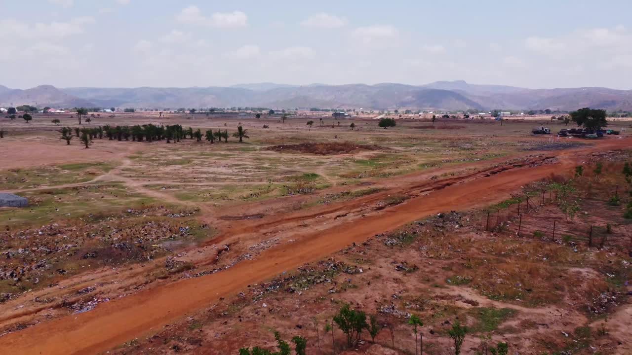Drone slowly flying over a small shack towards a vast and beautiful African landscape in rural Nigeria