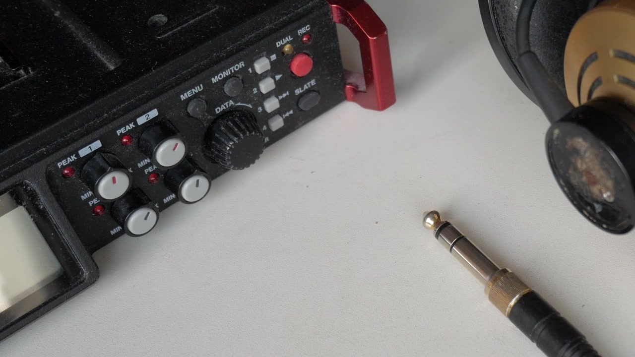 Peralatan Rekaman Audio di Meja Putih. Headphone dan Colokan Jack di Samping Perekam Portabel
