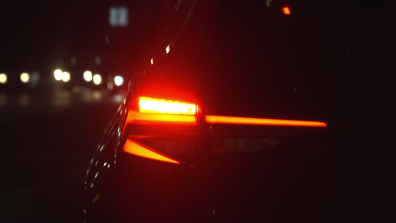 Close up of a car's blinker indicating the direction change at night