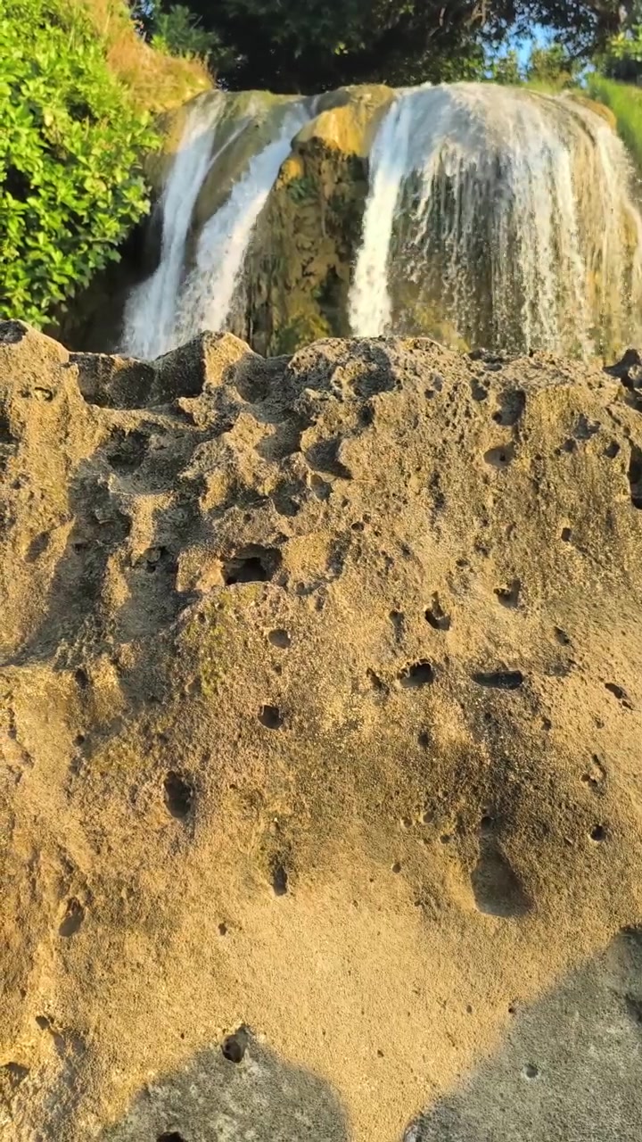 Cascata che si riversa su una scogliera rocciosa nella foresta tropicale