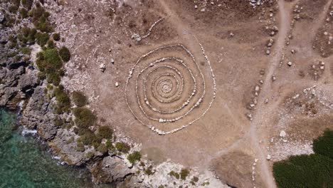 Mysterious-Spiral-out-of-stones-on-a-rocky-beach-in-italy