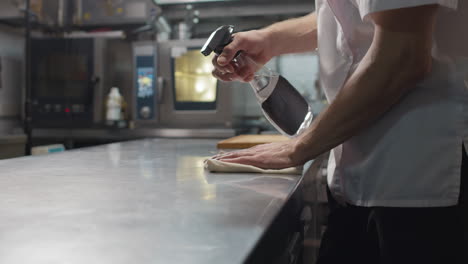 chef cleaning his workplace with disinfectant