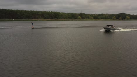 drone shot of foil surfer in wave behind