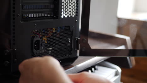 un técnico de reparación de computadoras ensamblando una nueva caja de pc para juegos con una herramienta de destornillador