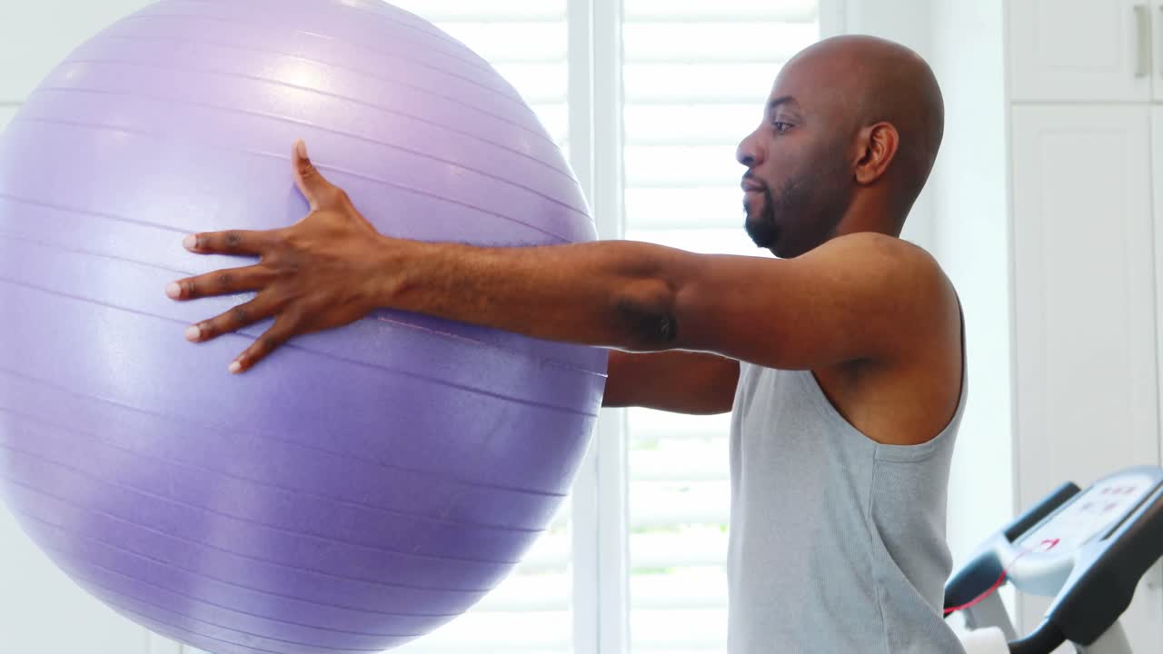 Man exercising with exercise ball 4k