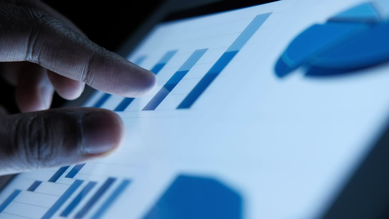 primer plano de la mano del hombre analizando el gráfico en una tableta digital