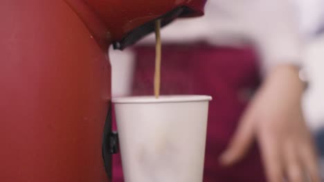 coffee being pour into a white cup from a coffee machine