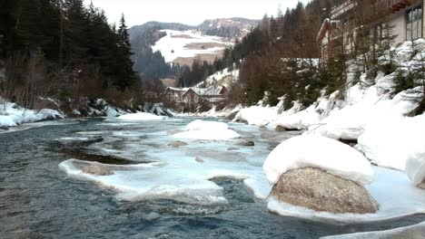 pequeña orilla del río congelado en un paisaje nevado durante el invierno