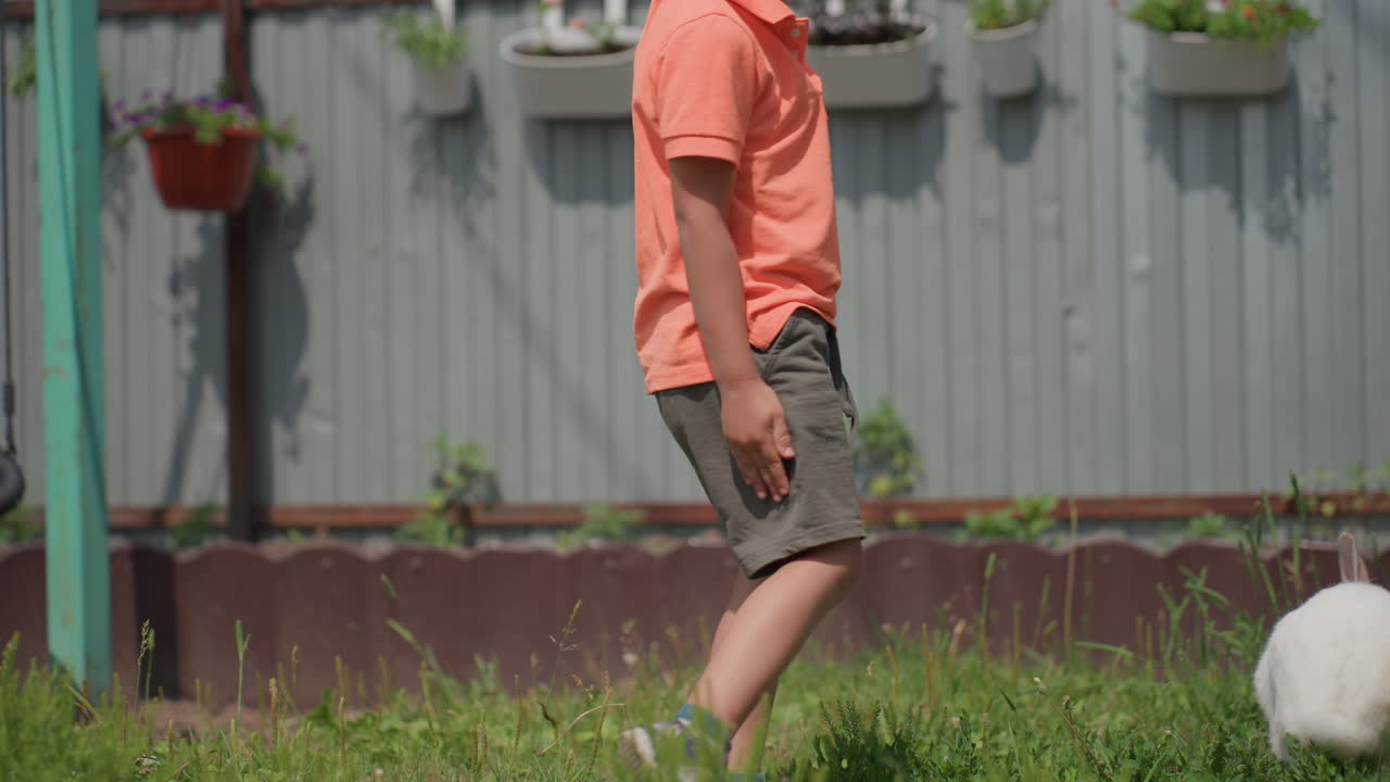Child Observes Adult Landscapers, Child Watches Adult Cut Grass, Youth Observes Grownup Tending To Lush Green Yard, Young Observer Watches Experienced Person Maintaining Grassy Outdoor Space