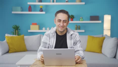 hombre mirando la computadora portátil haciendo un gesto positivo.
