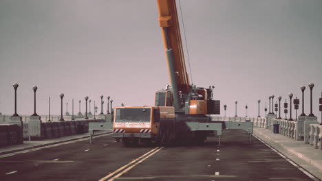 grúa móvil naranja en un puente