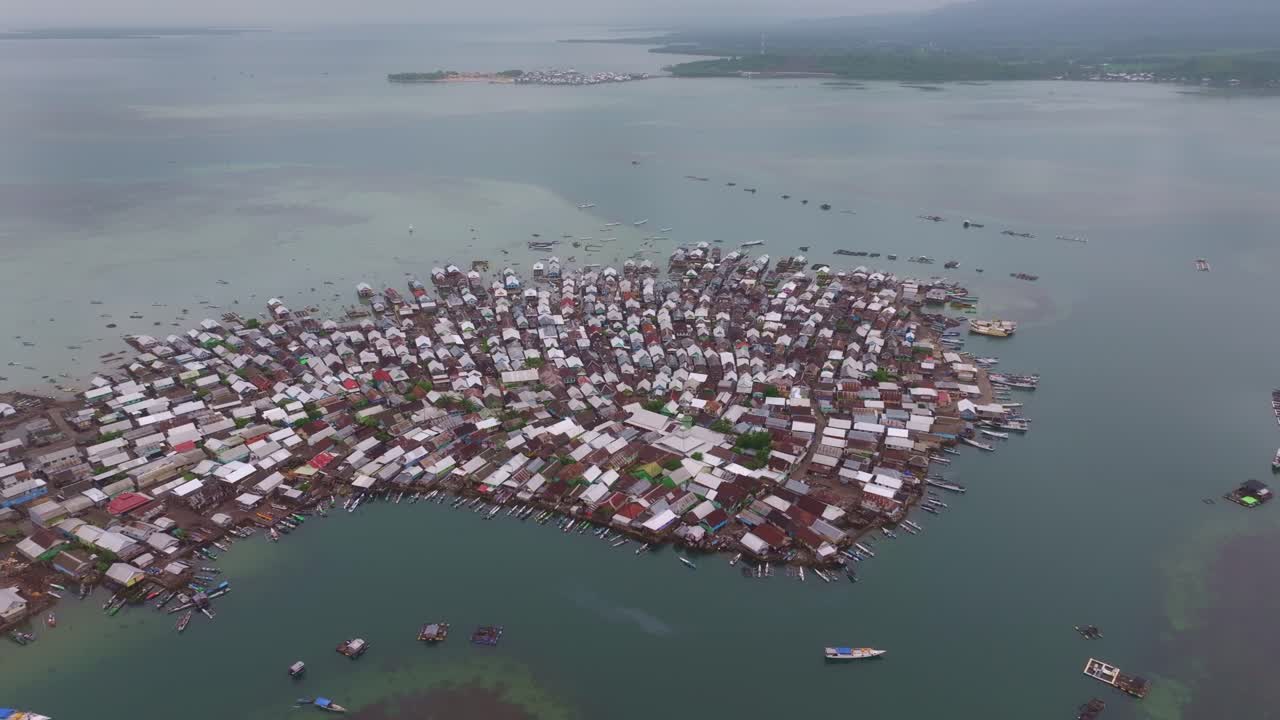 Sekelompok perahu tertambat di depan rumah-rumah desa tepi laut, Sumbawa, Indonesia