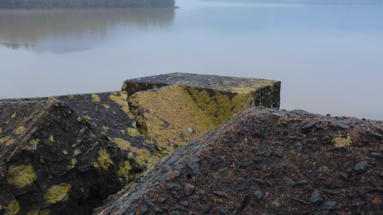 안개가 많은 신비로운 날에 평온하고 아름다운 산 호수 앞의 고대 돌 벽
