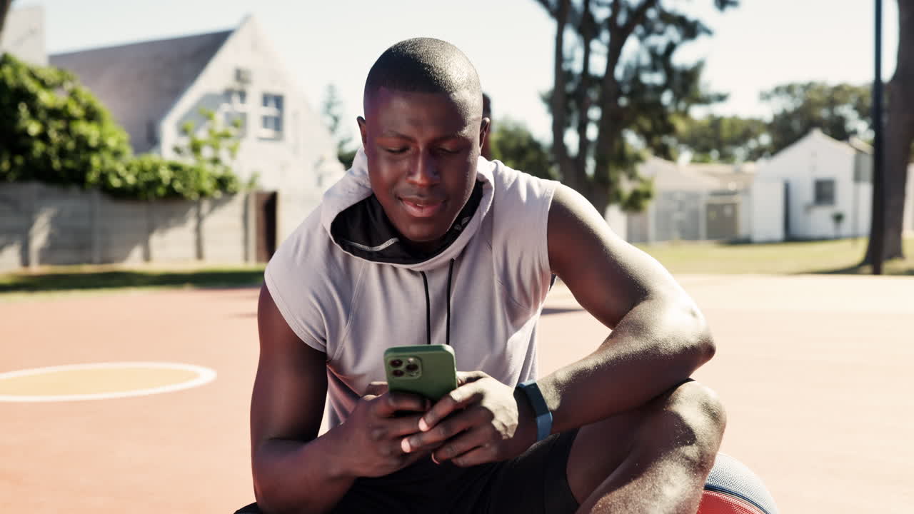 농구장에서 전화를 사용하는 남자