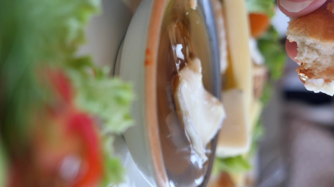 Dipping bread in butter and cheese with salad