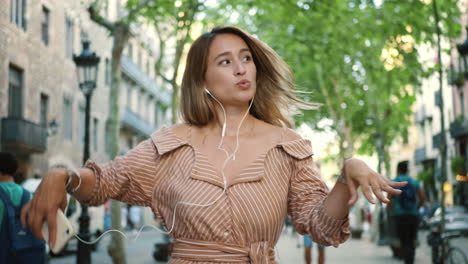 portrait of sexy woman dancing in earphones. girl relaxing with music outdoor.