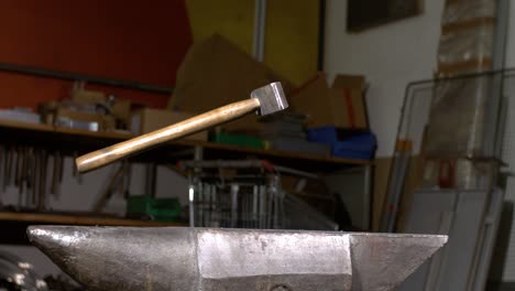 blacksmith hammer falling on an anvil in super slow motion