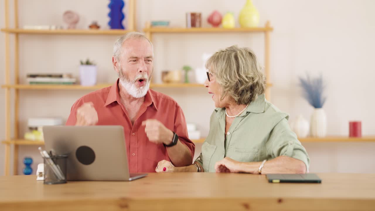 Pareja de ancianos celebrando el éxito en casa