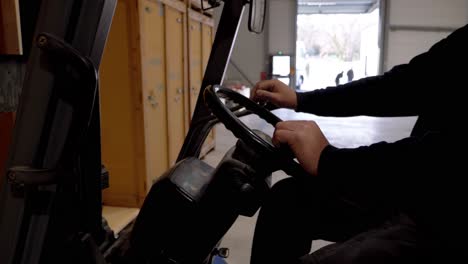 a forklift transporting pallets in a storehouse