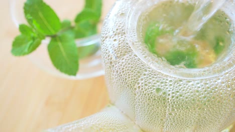 pouring hot water to fresh mint tea