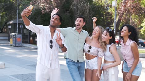 excited diverse friends taking self-portraits on city street