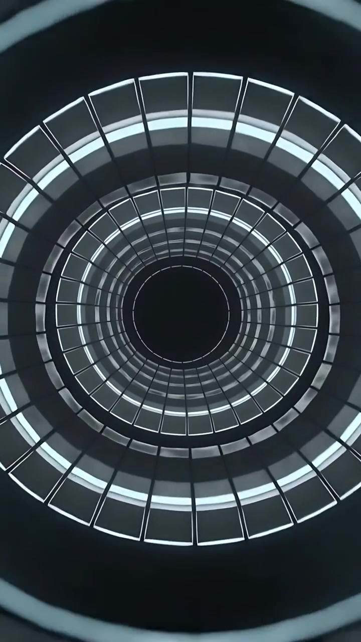 Video verticale: La telecamera si muove verso l'alto, zoomando per rivelare gli anelli interni di un atrio, mostrando fasce LED.