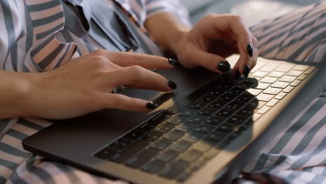 manager working laptop overtime in pajamas closeup. girl hands typing keyboard