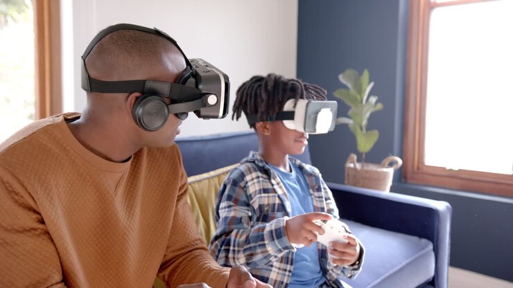 Padre e figlio afroamericani che giocano a un videogioco usando visori VR a casa, al rallentatore.