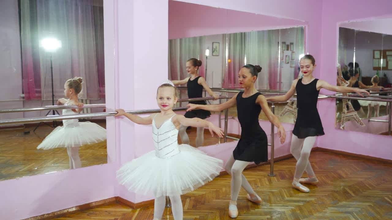 Beautiful ballerinas in black tutus at a ballet lesson. Lovely girls dance at ballet school.
