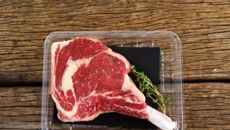 rib chop and herbs in plastic container