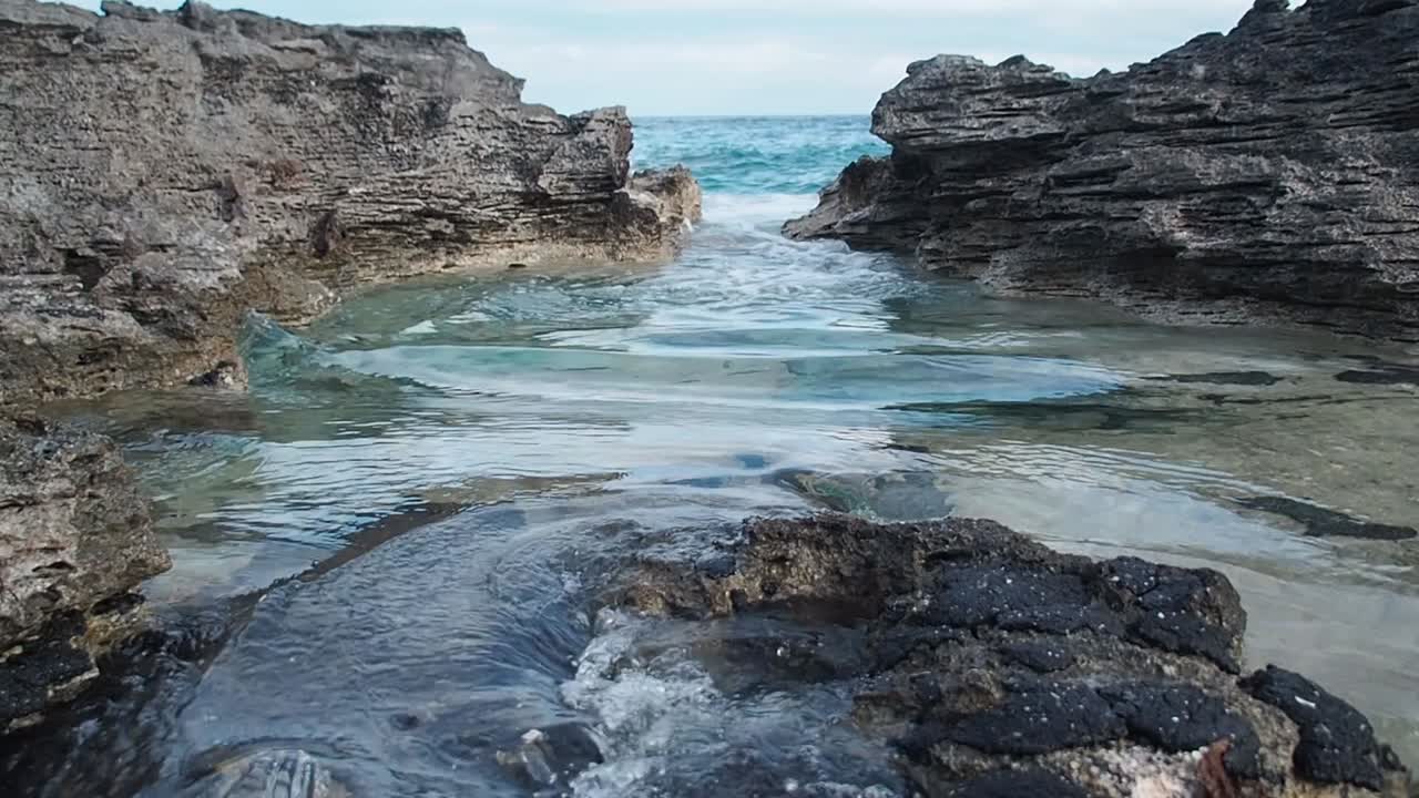 Acqua blu che si infrange sulle rocce.
