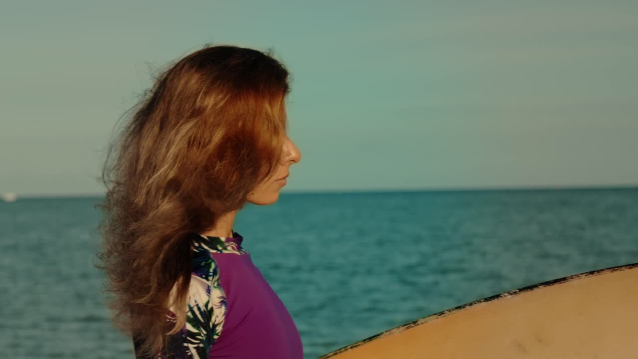 서프보드 를 들고 해변 에 있는 여자