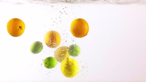 frutas cítricas salpicando bajo el agua